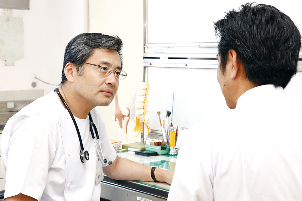 医師が患者と医療相談を行っている診察室の風景